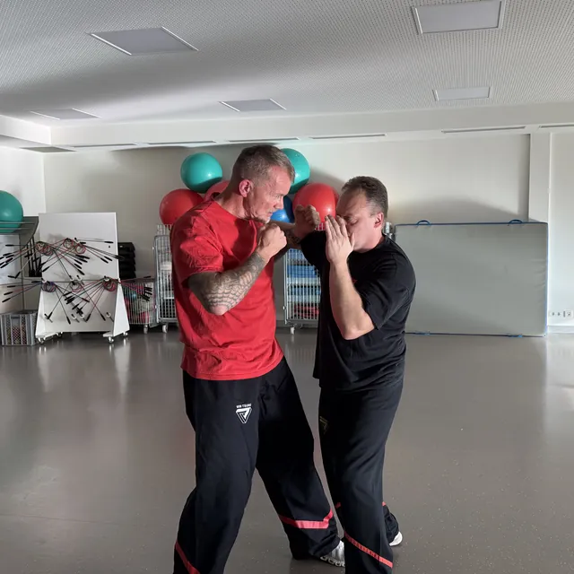 Trainer zeigt eine Abwehrbewegung im Firmenkurs der BG Klinik Ludwigshafen