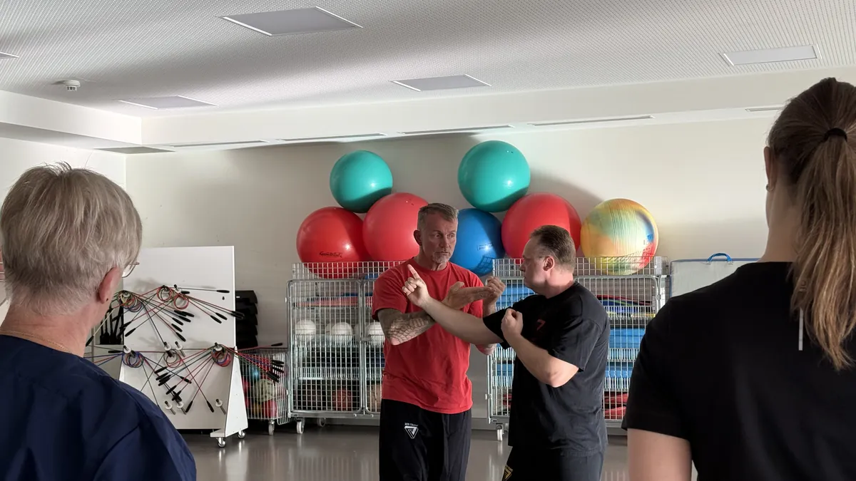 Zwei Trainer des Zentrums f&uuml;r Selbstverteidigung zeigen der Gruppe eine Befreiung aus einem Griff
